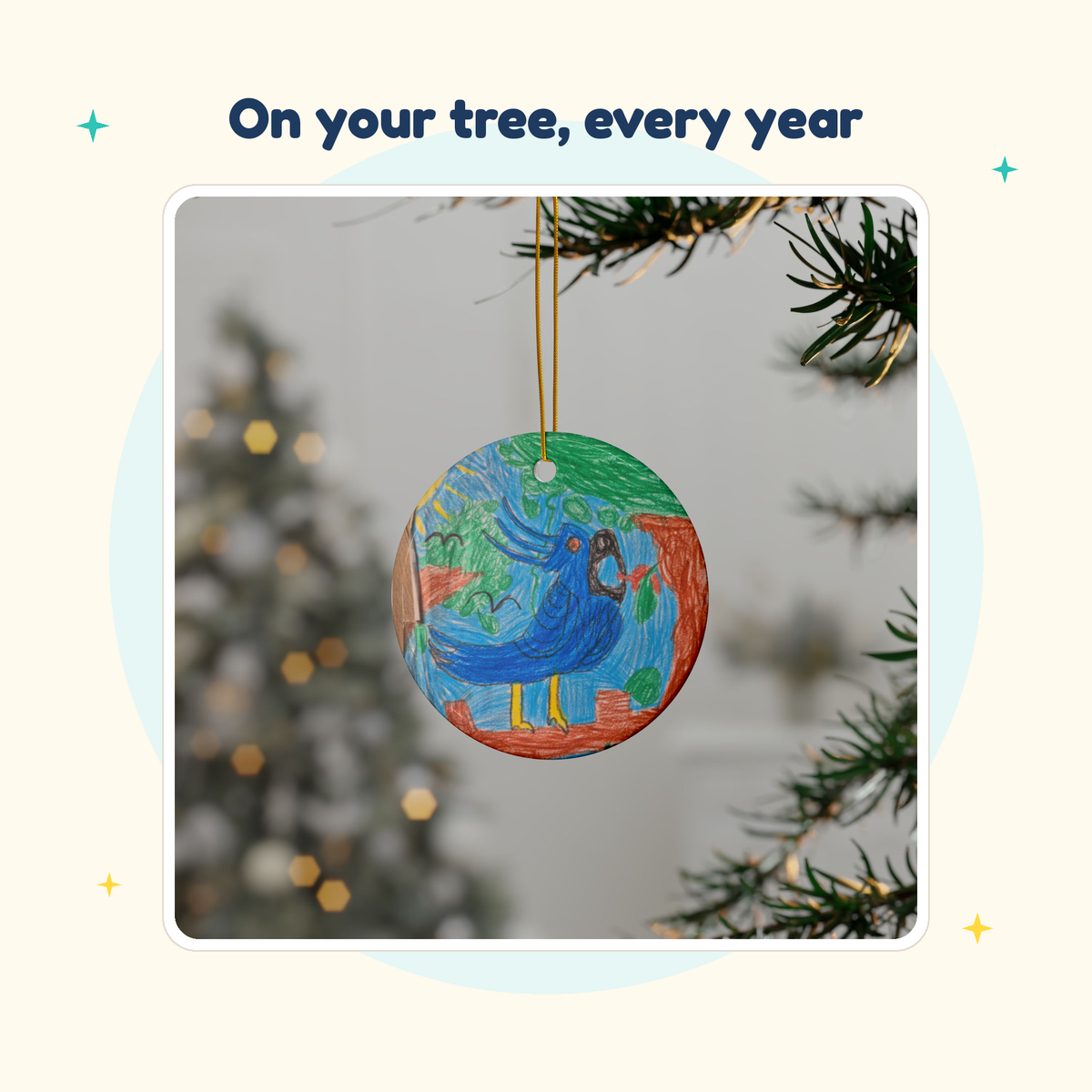 Ceramic Christmas ornament printed with a child's crayon drawing of a blue bird, hanging on a tree